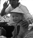En liten pojke med "riskkokar hatt" på huvudet